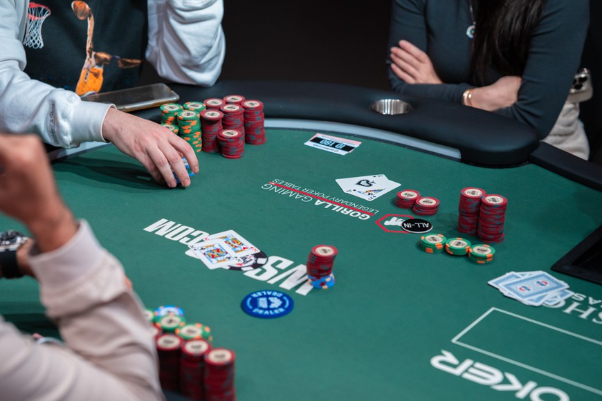 players are seen seated around a poker table with cards and chips and WSOP branding during the Secret Bounty NLH event at the 54th annual World Series of Poker. WSOP 2023 Sets Records: $150M in Prizes, Halfway to History!