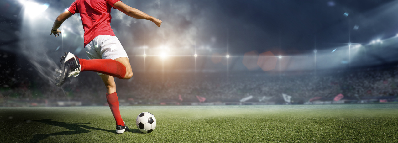 A football player is seen kicking a soccer ball in a stadium. Expert MLS picks and predictions for strategic soccer betting.