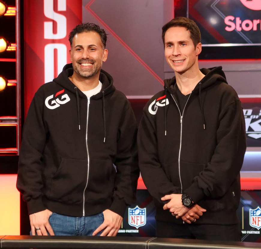 Jeff Gross and Ali Nejad are seen smiling and posing for the cameras. Each one wears a black GGPoker zip-up hoodie. The two were just named as GGPoker's newest GGTeam Ambassadors.