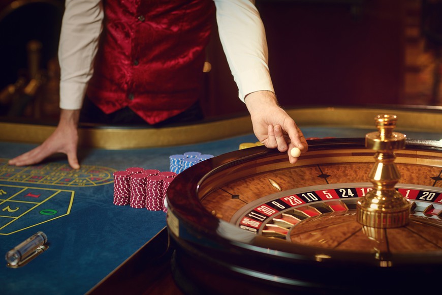 Croupier holds a roulette ball in a casino in his hand. -- Ontario Online Casino Live Dealer: What Games Can You Play?