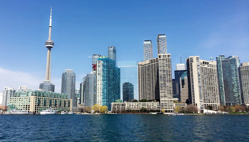 Toronto skyline is seen against blue sky. CN Tower and skyscrapers rise up from the shore of Lake Ontario. Ontario, Canada's biggest province, launched its regulated online poker, casino gaming, & sports betting market on April 4.