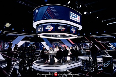 the PokerStars live studio main event table at EPT Monte Carlo. promo signs and lights surround a professional poker table where the main event will take place.