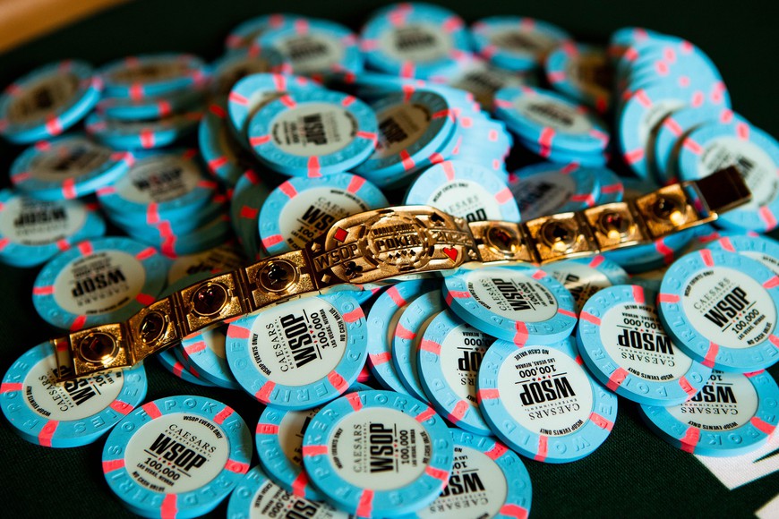Bahama blue poker chips with the WSOP logo are piled on a table with a 2023 WSOP gold bracelet sitting proudly on top. This Sunday is A Huge Day for WSOP & GGPoker Fans
